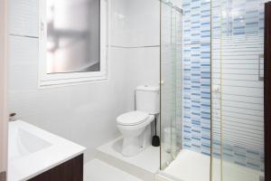 a bathroom with a toilet and a glass shower at AG Piso Fogar Carballo, 3 habitaciones in Carballo +3 photos