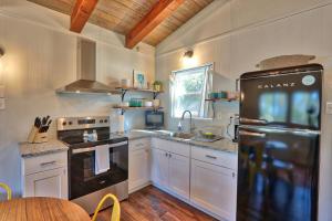 a kitchen with a black refrigerator and a table at Millies Cottages Unit 3 - Phyllis in Canyon Lake