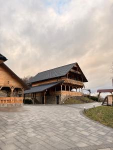 a large wooden building with a black roof at Cabana CORNESTEAN in Sighetu Marmaţiei