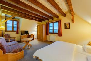 Scharrachbergheim IrmstettにあるHotel et Spa du Scharrachのベッドと椅子と机のある寝室