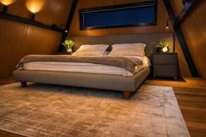 a bedroom with a large bed with a rug at Cabana Industrial in Palhoça