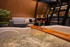 two glasses of red wine sitting on a bar in a bath tub at Cabana Industrial in Palhoça +10 photos