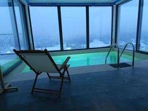 a chair next to a swimming pool in a building at Vrh house in Ravna Gora