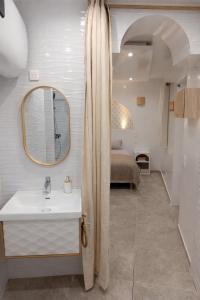 a bathroom with a sink and a mirror and a bed at Elohan Suite, parenthèse chic & cosy in Pontoise