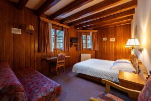 Scharrachbergheim IrmstettにあるHotel et Spa du Scharrachのベッドと机と椅子のある寝室
