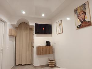 a room with a flat screen tv on a wall at Elohan Suite, parenthèse chic & cosy in Pontoise