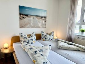 a bedroom with two beds with pillows at Ferienwohnung De Diek 103 in Dorum-Neufeld