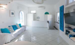 a white living room with a couch and a tv at Rooftop luxury apartment in Capri