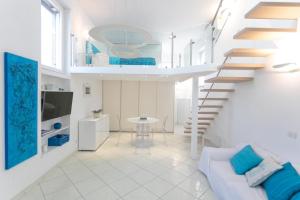 a white living room with a staircase and a couch at Rooftop luxury apartment in Capri