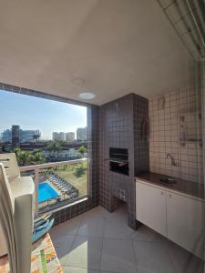 a kitchen with a large window with a view at terraços do maitinga in Bertioga