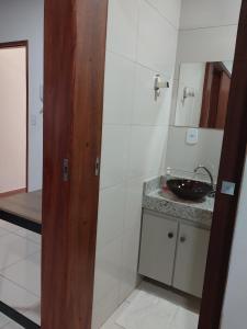 a bathroom with a sink and a mirror at Bem Estar no Bom Ap 2 in Arapiraca