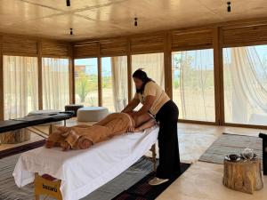 a woman is cutting a man on a bed at Kymaia Hotel Puerto Escondido in Tlachicón