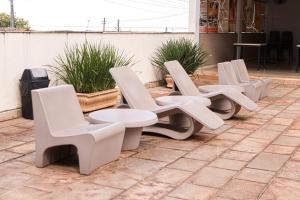 a row of white chairs and tables on a patio at Mais Hotel in Araguaína