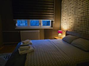 a bedroom with a bed with towels on it at Lungro's Square Apartment in Skopje