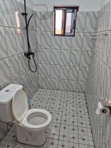 a bathroom with a toilet and a window at G and E Guesthouse in Kumba +10 photos