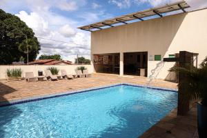 a swimming pool in front of a house at Mais Hotel in Araguaína