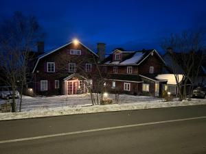 a large brick house with a light on the roof at Auberge la Romance in La Malbaie