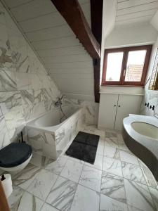 a bathroom with a tub and a toilet and a sink at Good N8 Apartment in Wabern +18 photos