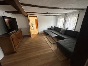 a living room with a couch and a tv at Good N8 Apartment in Wabern