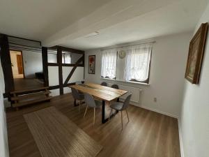 a dining room with a wooden table and chairs at Good N8 Apartment in Wabern