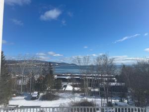 a view of a snow covered yard with a lake at Auberge la Romance in La Malbaie +17 photos