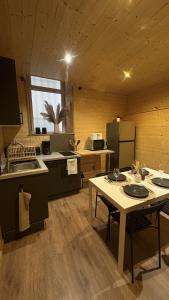 a kitchen with a table and a refrigerator at Le petit chalet de Cholet in Cholet