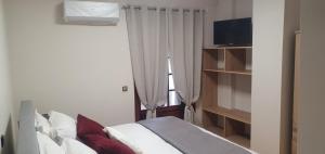 a bedroom with a bed and a window at a&bpikermistudios4 in Pikérmion