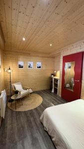 a bedroom with a bed and a chair and a table at Le petit chalet de Cholet in Cholet