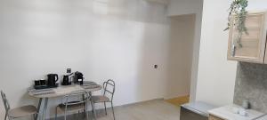 a white room with a table and chairs in a kitchen at a&bpikermistudios4 in Pikérmion +7 photos