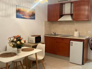 a kitchen with a small table and a white refrigerator at Apartamentos Amy 3 con vista a mar in Palos de la Frontera