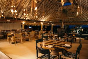 a restaurant with tables and chairs and lights at Kymaia Hotel Puerto Escondido in Tlachicón