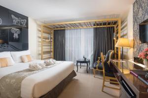 a hotel room with a large bed and a desk and a desk at Nimman Mai Design Hotel Chiang Mai in Chiang Mai