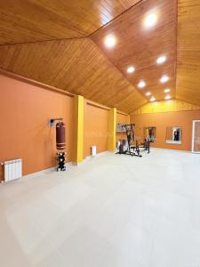 a large room with a gym with a wooden ceiling at Novxanı Villa in Baku