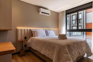 a bedroom with a bed and a window at 2-suite apartment just a few meters from Rua Coberta. in Gramado +22 photos