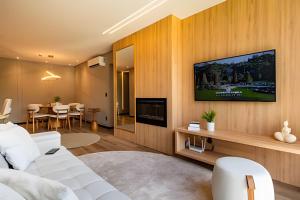a living room with a white couch and a tv at 2-suite apartment just a few meters from Rua Coberta. in Gramado