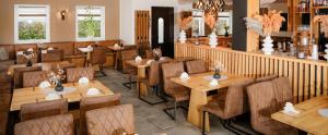 a restaurant with wooden tables and chairs at Zum Obstler - Gaststätte und Pension in Gera