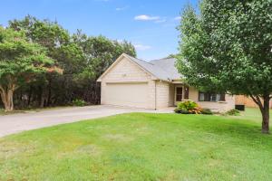 a white house with a garage in a yard at Woodacre Cottage in Wimberley +18 photos