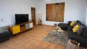 a living room with a couch and a flat screen tv at Can Catalina in Can Furnet