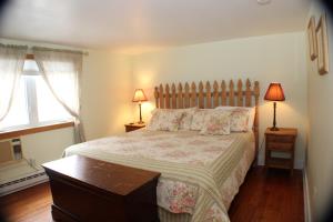 a bedroom with a large bed with two lamps on two tables at The Inn at Quail Run in Wilmington +26 photos