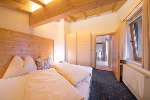 um quarto com uma cama branca e uma cabeceira em madeira em Apart-Haselwanter em Mieming