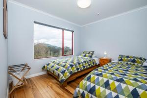 a bedroom with two beds and a window at Omori Lodge in Tokaanu