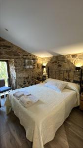 a bedroom with a large bed with towels on it at A Caseta, en plena Costa da Morte in A Coruña