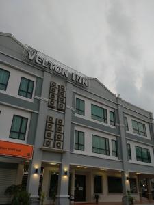 a grey building with a yellow inn sign on it at The Velton Inn in Bintulu
