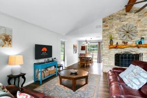 a living room with a couch and a stone fireplace at Arrowhead Falls in Wimberley