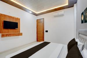 a bedroom with a bed and a tv on the wall at Townhouse Tuessday Suites Nearst Mr Bhatura Bala Sector 122 in Noida