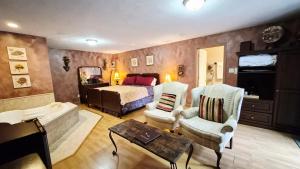 a bedroom with a bed and a tub in a room at Auberge Wild Rose Inn in Moncton