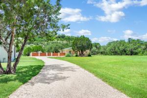 a gravel path through a green field with a house at Artista in Wimberley
