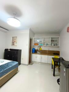 a bedroom with a bed and a kitchen at 29 Palm's Panglao Suites in Panglao Island