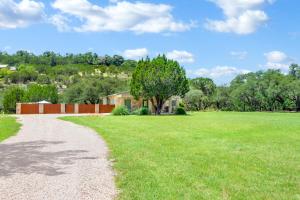 a path leading to a field with a tree at Artista in Wimberley