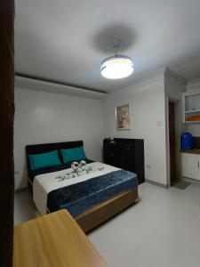 a bedroom with a large bed with blue pillows at 29 Palm's Panglao Suites in Panglao Island